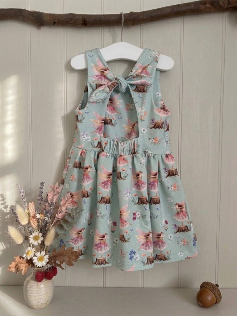 Rabbit & Hare Woodland Fairy dress in Mist — organic cotton dress with hand-painted fairies dancing on tree stumps, with a tie-back detail